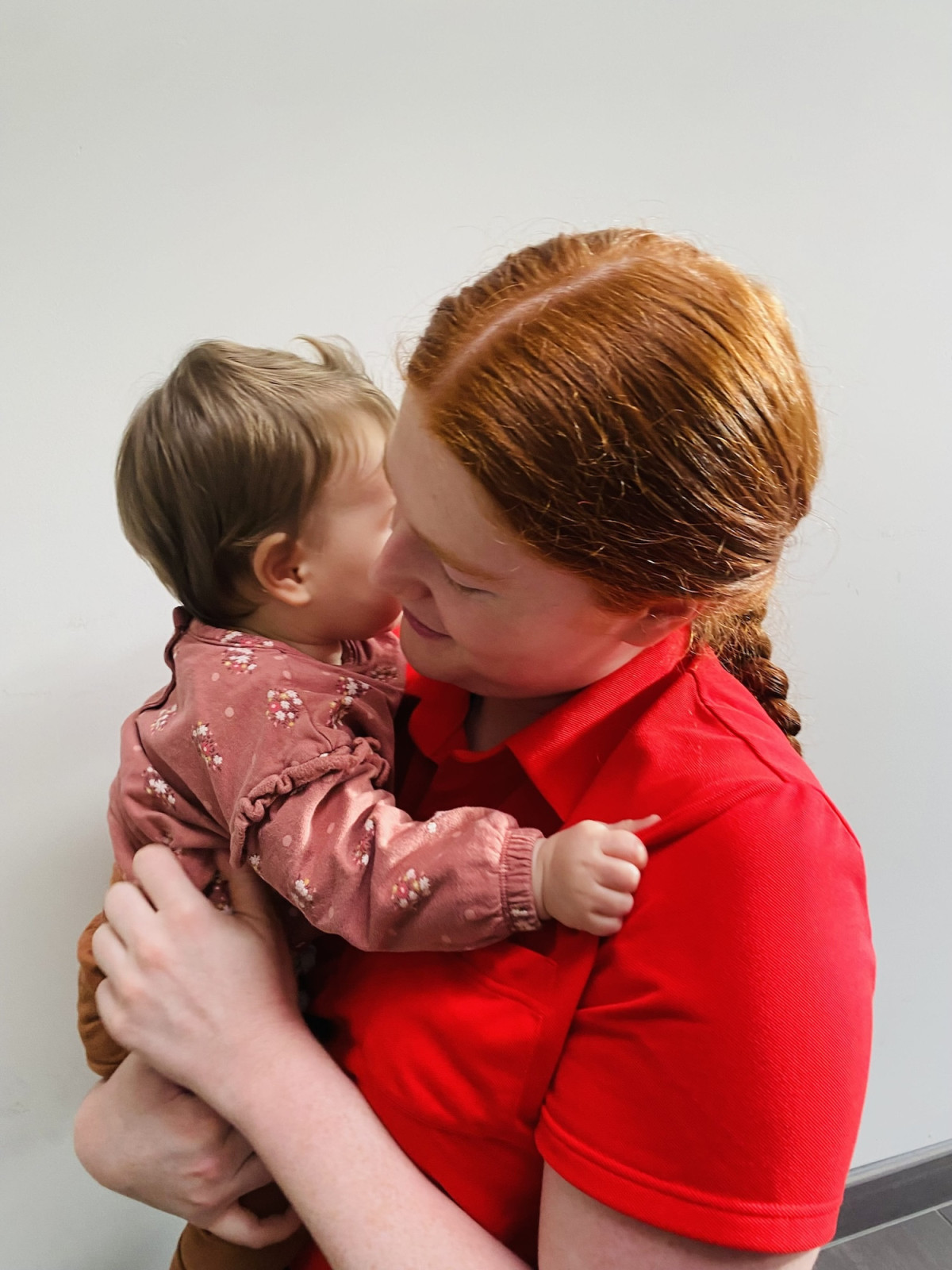 Een medewerker van Peuterhuisje die een baby vasthoudt na een flesje